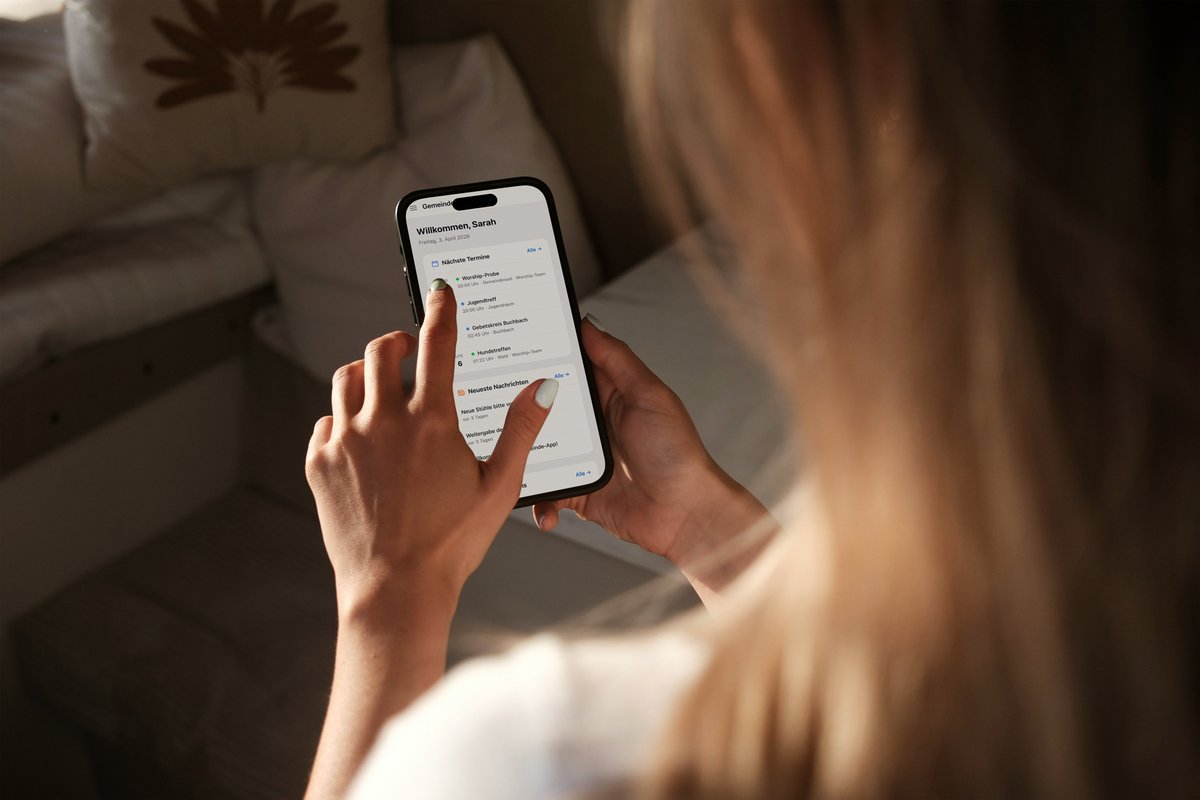 Frau nutzt die Qehillah Gemeinde-App auf dem Smartphone mit Terminübersicht und Nachrichten